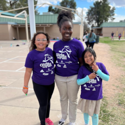 Three GOTR Girls in purple program shirts, outside at practice. 